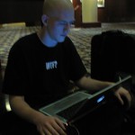 Justin Chapweske zens out with his PowerBook on the hotel lobby carpet.