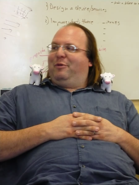 Ethan Zuckerman with Tucows squishy cows on his shoulders.