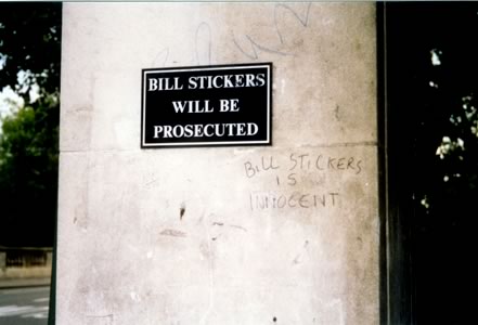 Sign under bridge: “Bill stickers will be prosecuted”, and beside it, grafitti that reads “Bill Stickers is innocent!”