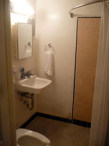 20. Hotel Cecil in-room bathroom, showing sink, toilet and shower area