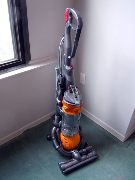 Dyson DC25 "Ball" vacuum sitting in the corner of a room.