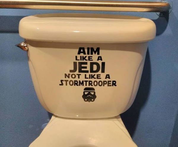 Toilet with a sign that reads 'Aim like a Jedi, not like a stormtrooper.'