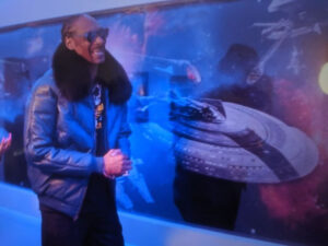 Photo: Snoop Dogg posing in front of his wall mural featuring Star Trek ships in space