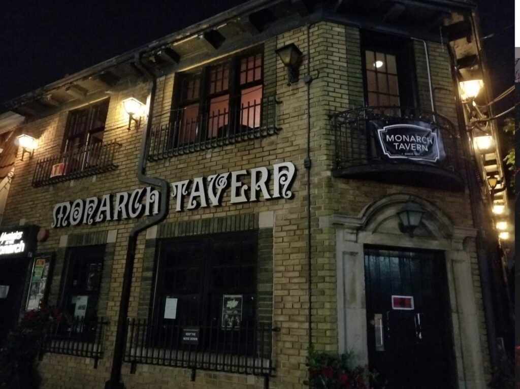 The exterior of the Monarch Tavern (Toronto) at night.