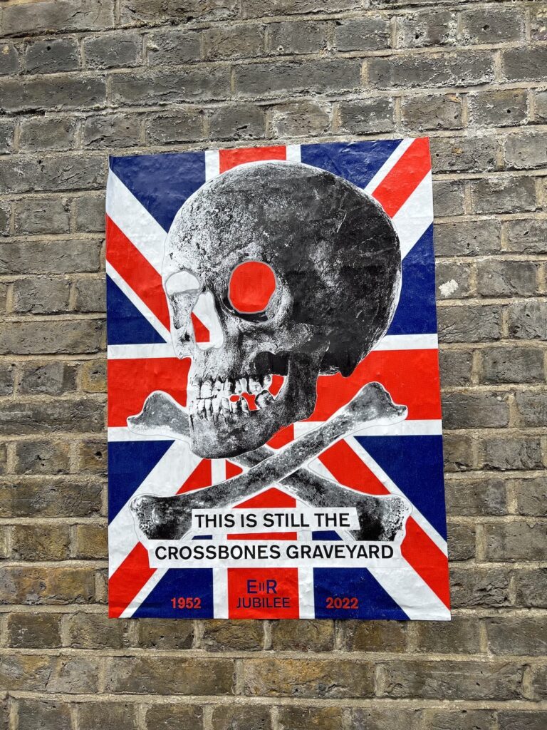 Photo: “This is still the crossbones graveyard” poster depicting skull and crossbones with Union Jack background.