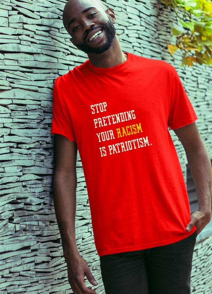 Black man wearing T-shirt that says “Stop pretending your racism is patriotism.”