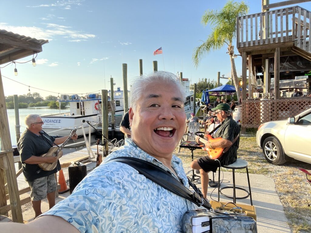 Joey deVilla playing accordion on a pier with Tom Hood and Tropical Sons.