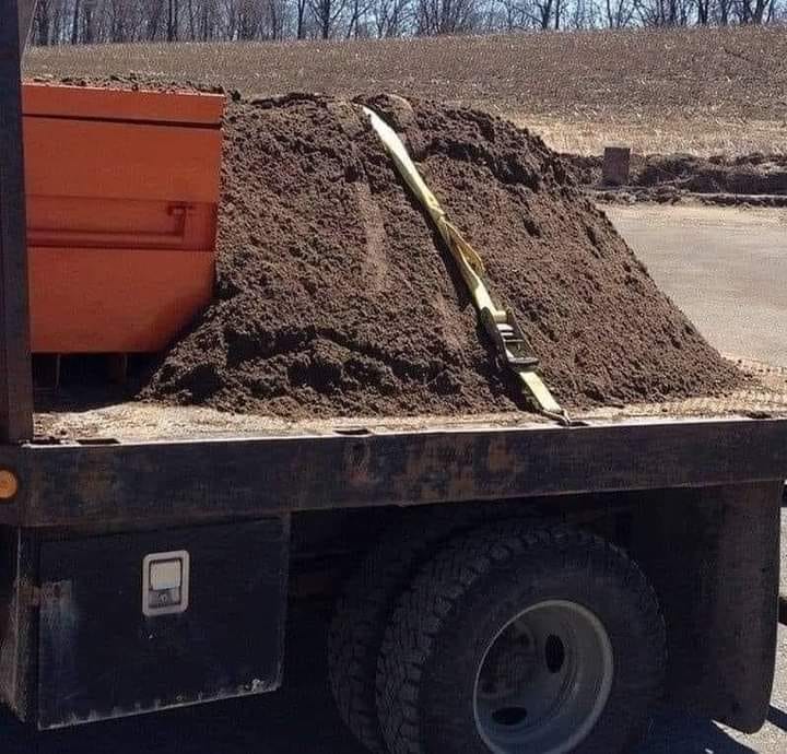 Photo: Loose dirt “held down” on a flatbed truck with a strap.