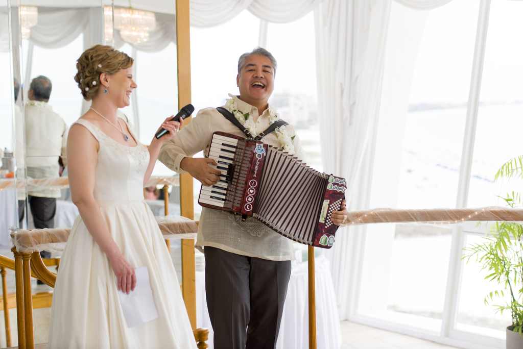 Anitra Pavka and Joey deVilla wedding photo: Anitra holds a mic while Joey plays accordion.