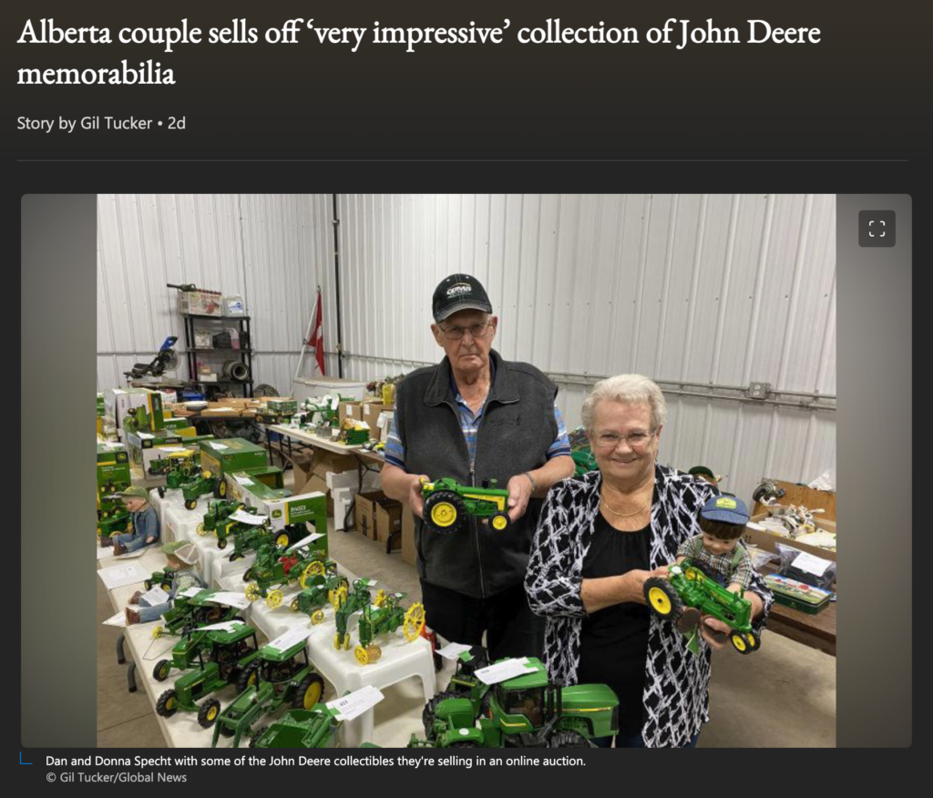 News clipping titled “Alberta couple sells off ‘very impressive’ collection of John Deere memorabilia” with photo of couple standing among a collection of toy John Deere tractors. Dan looks dejected; Donna is beaming.