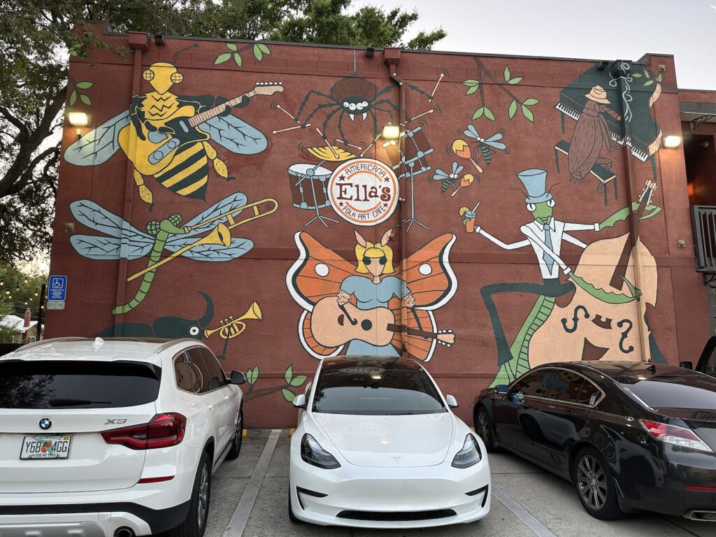 The mural on the back wall of Ella’s Americana Art Cafe, featuring various insects as a band on their musical instruments.